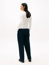 Remera blanca de algodón con textura acanalada, corte slim, cuello redondo con tapeta de botones dorados y manga larga.