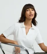 Polo de manga corta color marrón, con cuello abierto y tejido de suedine de algodón BCI.
