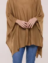 Poncho de calce holgado color marrón, confeccionado en tejido fino de punto suave, con cuello redondo y diseño de caídas laterales amplias de ruedo asimétrico.
