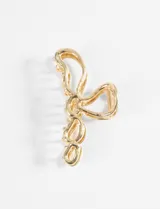 Broche metálico dorado con diseño de lazo.