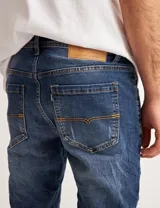 Jean azul con efecto lavado y roturas, de corte ajustado.