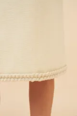 Falda midi de lana color gris con textura tweed y corte recto. Presenta un galón tejido marrón en el ruedo y forro al tono.