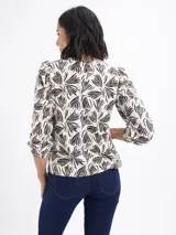 Remera de algodón con estampado botánico abstracto en color negro sobre fondo beige, de cuello redondo, mangas largas abullonadas y puños elásticos con detalle de frunce.