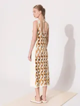 Vestido negro midi con aberturas geométricas y tiras finas.