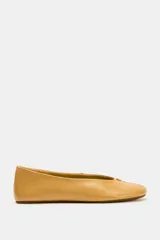 Zapato tipo bailarina plana de piel en color tostado, con pespuntes en el cuerpo, detalle metálico en la parte delantera y acabado en punta redonda.