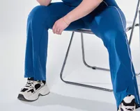 Pantalón de jogging azul con una línea blanca a lo largo de la pierna.