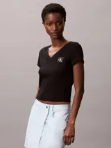 Remera de Calvin Klein confeccionada en punto de algodón elástico con textura de canalé fino. Presenta un diseño de corte slim, cuello en V, manga corta y una insignia con el logo de la marca en el pecho.