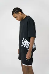 Remera oversize negra de algodón elastizado con estampado blanco en el frente.