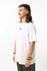 Remera blanca de algodón con estampado en la espalda que muestra un dibujo de un personaje con micrófono señalando una tierra plana con el texto "The Earth is Flat".