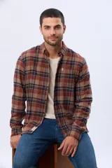 Camisa de viyela a cuadros en tonos marrón, azul marino y gris, con cuello clásico, cierre frontal con botones, mangas largas y un bolsillo en el pecho.