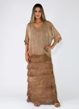 Pollera larga de viscosa color beige con diseño de múltiples capas y volados superpuestos de terminación rústica deshilachada.