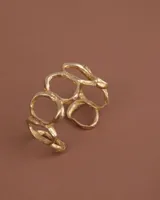 Brazalete rígido de diseño orgánico, compuesto por eslabones irregulares unidos entre sí, con acabado metálico brillante.