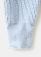 Sweater de punto celeste con cuello polo y cierre frontal en V, manga larga con puños ajustados y diseño acanalado.