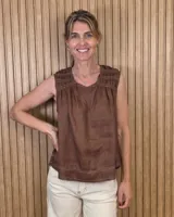 Musculosa de lino marrón oscuro, sin mangas, con escote redondo, detalles de frunces y tablas en los hombros, y costuras pespunteadas en contraste con dobladillo deshilachado.