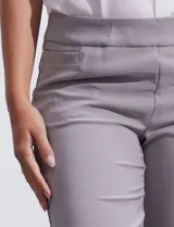 Pantalón sastrero de corte slim, color blanco, con pretina anatómica y panel interno modelador. Presenta bolsillos laterales tipo ojal, bolsillos traseros simulados y nervadura vertical marcada en el frente.