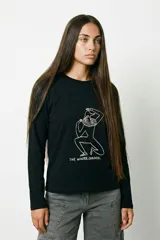 Remera de manga larga color negro, con cuello redondo y estampa lineal en color blanco que representa una figura humana con cuello de volados y el texto The Winter Carousel.