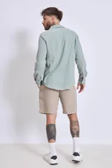 Camisa celeste de manga larga con textura arrugada.