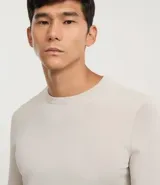 Suéter de corte regular, cuello redondo y manga larga, confeccionado en tejido de viscosa con textura suave y caída ligera.