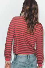 Camiseta de manga larga con diseño de rayas horizontales en color fucsia y verde oliva. Presenta cuello redondo y puños acanalados en color fucsia.