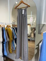 Vestido largo de lino color negro oscuro, con escote fruncido y tirantes finos ajustables. Presenta aberturas laterales en el ruedo.