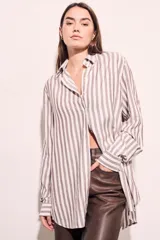 Camisa oversize a rayas verticales color beige y blanco, de mangas largas y corte holgado.