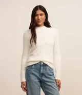 Suéter corto de punto liviano color blanco, con cuello alto y mangas largas.