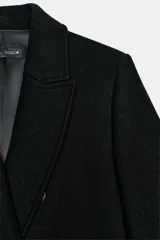Abrigo largo de corte recto confeccionado en mezcla de lana, con cuello de solapa, manga larga con detalle de botones en puños y cierre frontal cruzado con botones.