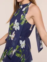 Vestido maxi Julia Jordan de gasa estampada azul con flores blancas y hojas verdes, escote halter y diseño estructurado en paneles volados.