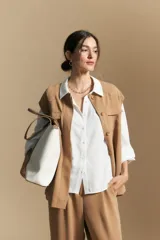 Camisa de manga larga con caída fluida, diseño de silueta suelta, cuello clásico y cierre frontal con botones.