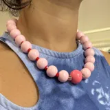 Collar corto de cuentas de madera pintadas de color rosa, intercaladas con cuentas de cristal checo rojas y transparentes.