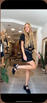 Pollera corta tipo falda-short de color negro, con diseño cruzado en el frente y cintura de tiro medio. Confeccionada en cuero genuino por artesanos uruguayos.