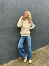 Sweater de tejido de punto color crudo, con diseño de ochos en el frente y punto morley en mangas y espalda. Presenta cuello redondo a la base y mangas largas.