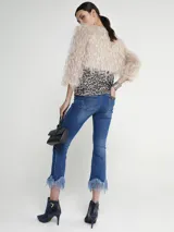 Pantalón de jean azul con corte cropped y terminación desflecada con ondas en el ruedo.