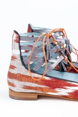 Botines con estampado de lenguas mallorquinas en color teja, con pieza de piel gris antracita en el tobillo y cordones de algodón con borlas de piel. Incluyen plantilla de piel y plantilla extra de lana intercambiable.