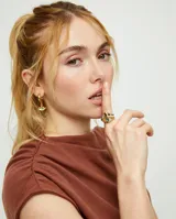 Anillo dorado con forma de ojo y cristal facetado verde. Fabricado en aleación de metales bañado en oro 18k.