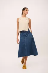 Falda midi de jean azul oscuro, con corte ligeramente acampanado y detalle de costura central vertical. Presenta paneles horizontales a la altura de la cadera que simulan bolsillos.