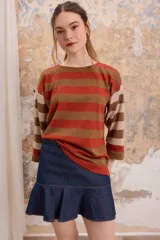 Blusa estilo remera de manga tres cuartos con corte recto y diseño a rayas horizontales en tonos marrón, naranja y beige.