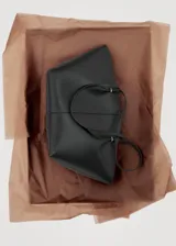 Bolso tipo shopper de efecto piel, con doble asa de hombro, cierre de botón magnético y bolsillo interior con cremallera.