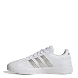 Championes urbanos Adidas modelo Grand Court Base 2.0, color blanco con las icónicas tres franjas laterales en tono gris metalizado. Presentan un diseño inspirado en los años 70 con suela tipo cupsole de caucho y cierre mediante cordones.