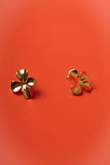 Aros tipo stud con diseño de flor de cuatro pétalos en acabado dorado brillante.