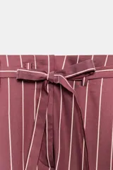 Pantalón de tiro medio color bordó con diseño de rayas verticales finas en tono claro. Presenta corte holgado, bolsillos laterales y cintura ajustable con cordón para atar.