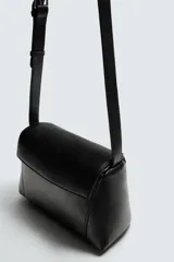 Bolso bandolera negro de piel con textura, cierre de solapa con imán y cremallera. Incluye bolsillo interior con cremallera y bolsillo plano. Asa de hombro ajustable de piel.