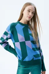 Sweater de tejido de punto con diseño geométrico multicolor en tonos verde, azul y lila. Presenta cuello redondo, mangas largas con puños acanalados y corte recto.