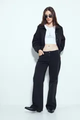 Pantalón de jean negro de tiro medio y corte recto, con diseño de cinco bolsillos y cierre frontal con botón y cremallera.