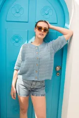 Saco tejido calado color ocre, con mangas al codo y botones de coco. Tiene grifa de cuero en la espalda.