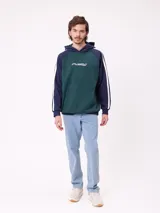 Canguro con capucha de estilo deportivo, con cuerpo en color celeste y mangas raglán en color negro. Presenta el logo de la marca estampado en el pecho, bolsillo tipo canguro frontal y franjas blancas laterales en las mangas.