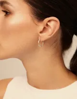 Aros tipo argolla de diseño orgánico y minimalista, con acabado plateado brillante.