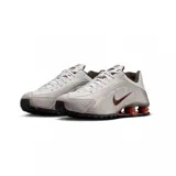 Championes Nike Shox R4, color negro y plateado, con diseño aerodinámico y sistema de amortiguación de columnas Shox en el talón.