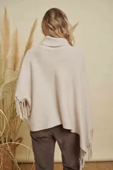 Poncho tejido de punto acanalado en color marrón chocolate, con cuello alto y diseño irregular con flecos en los bordes.