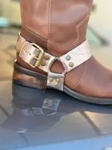 Bota de cuero marrón con estribo desmontable plateado.